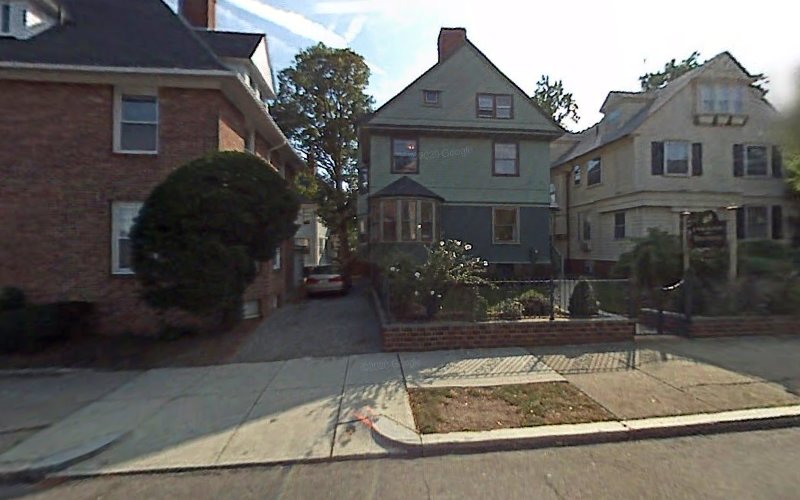 Street view of multi-story residential buildings in brick and colored siding