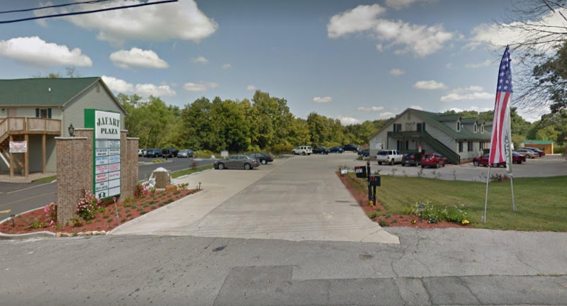 Beckley Psychiatric Services medical plaza exterior with parking lot, American flag, and multi-unit brick building