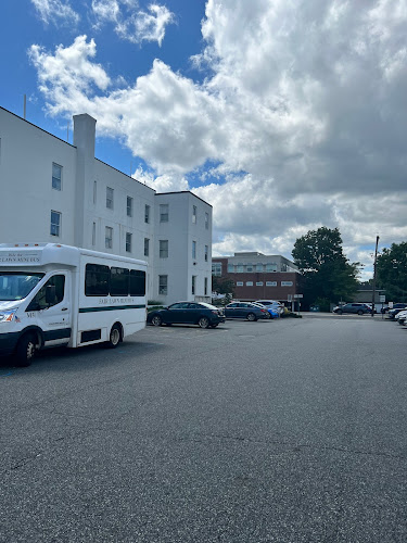 Blossom Psychiatry white office building with parking lot and parked vehicles