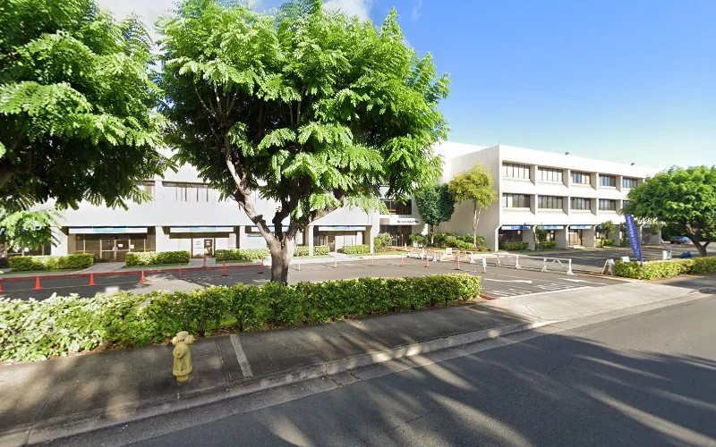 Modern medical building with green landscaping and large shade tree in Hawaii setting