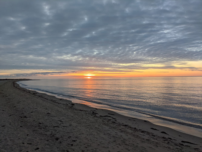 Sunset over ocean beach with waves and sand