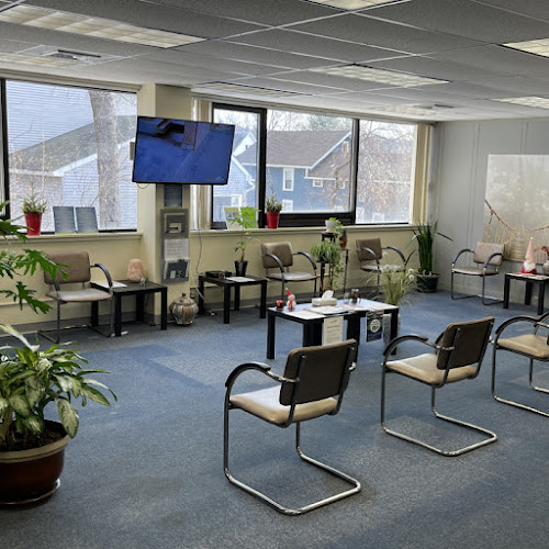 CleanSlate waiting room with chairs, plants, television, and windows overlooking residential area