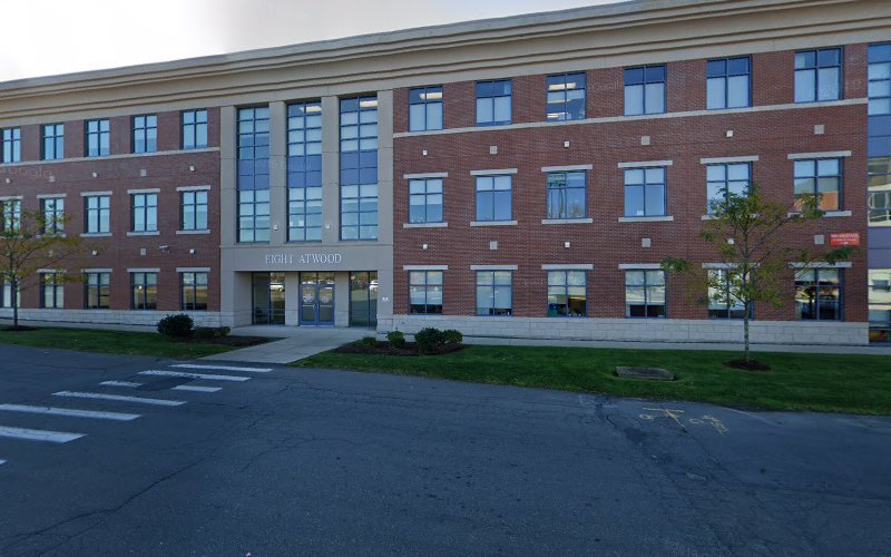 Clinical & Support Options multi-story brick building with large windows and parking area