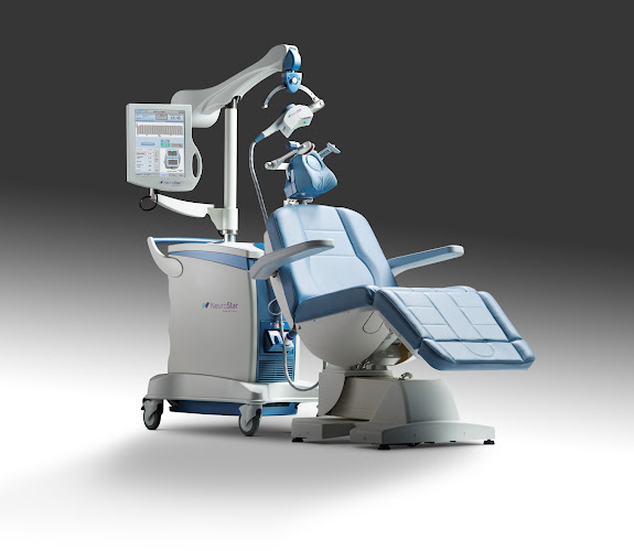 TMS therapy device with control panel and patient chair in clinical setting