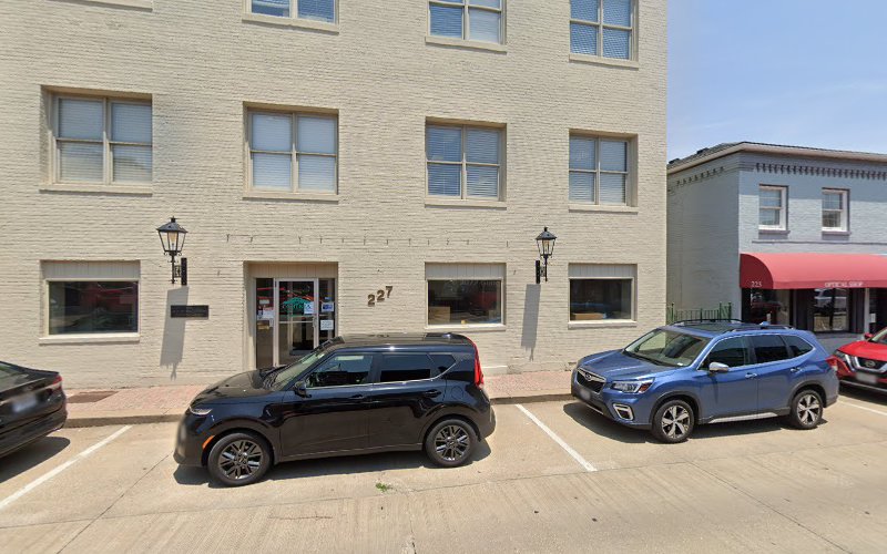Compass Health Network brick building exterior with entrance at street level and parked cars