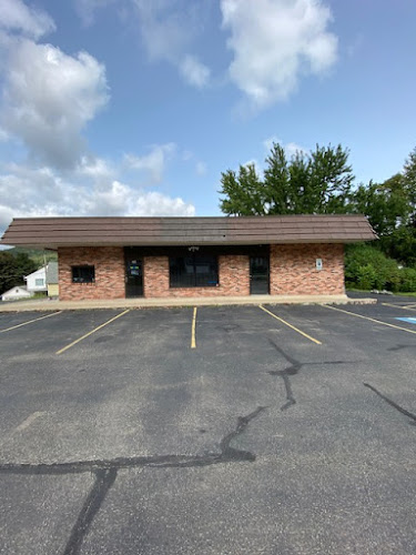 Single-story brick treatment facility with parking lot and clear sky