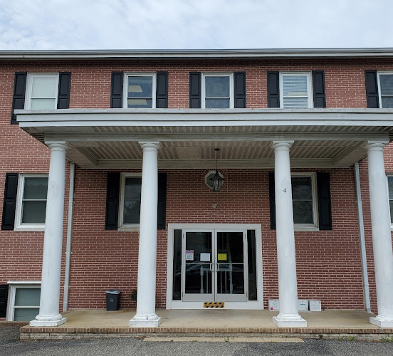 Red brick building with white columned entrance and dark shutters
