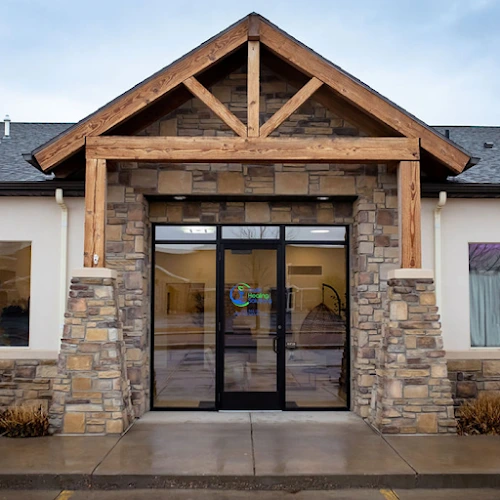 Delta Healing Solutions entrance with stone and wood facade and glass doors