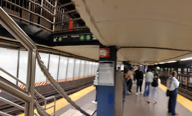Subway platform with passengers waiting and train doors visible