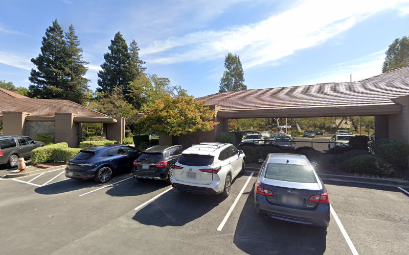 Medical office building exterior with covered parking lot and multiple parked vehicles
