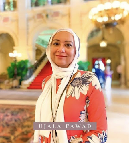 Dr. Ujala Fawad wearing a white hijab and red floral dress
