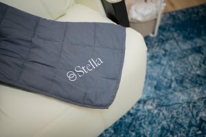 Stella branded weighted blanket draped over white furniture