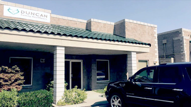 Duncan Family Healthcare building exterior with teal roof and parked vehicle