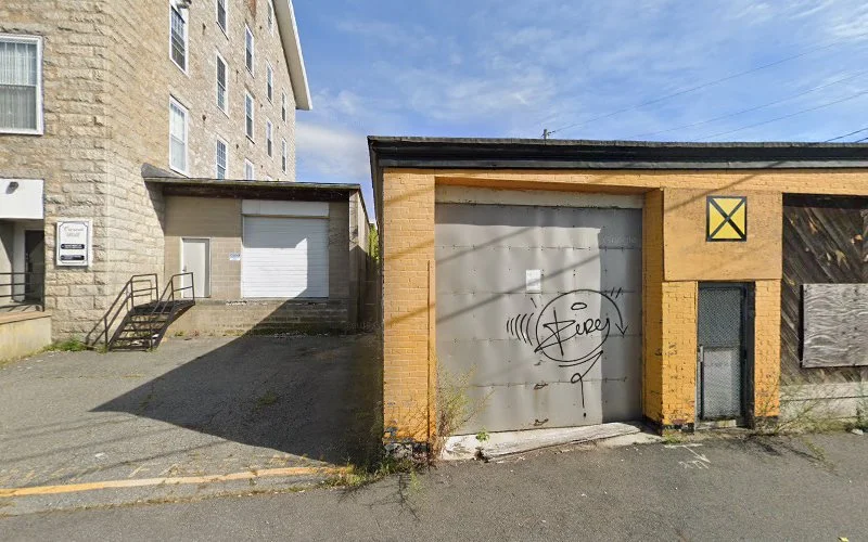 Exterior view of stone and yellow-brick clinic buildings with garage door and marked entrance