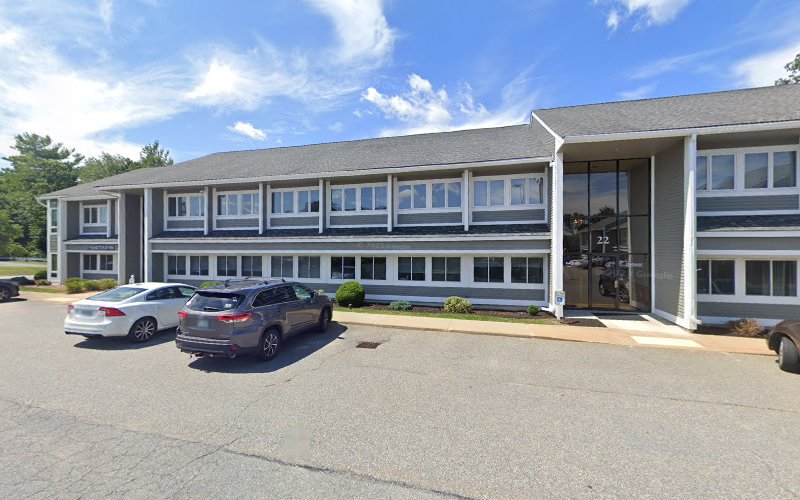 Modern two-story gray and white medical facility with multiple windows and parking lot
