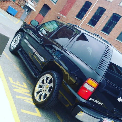 Two dark SUVs parked in marked spaces outside brick treatment facility building