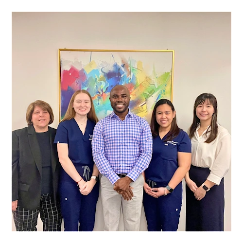 Five mental health professionals standing together in front of colorful abstract artwork
