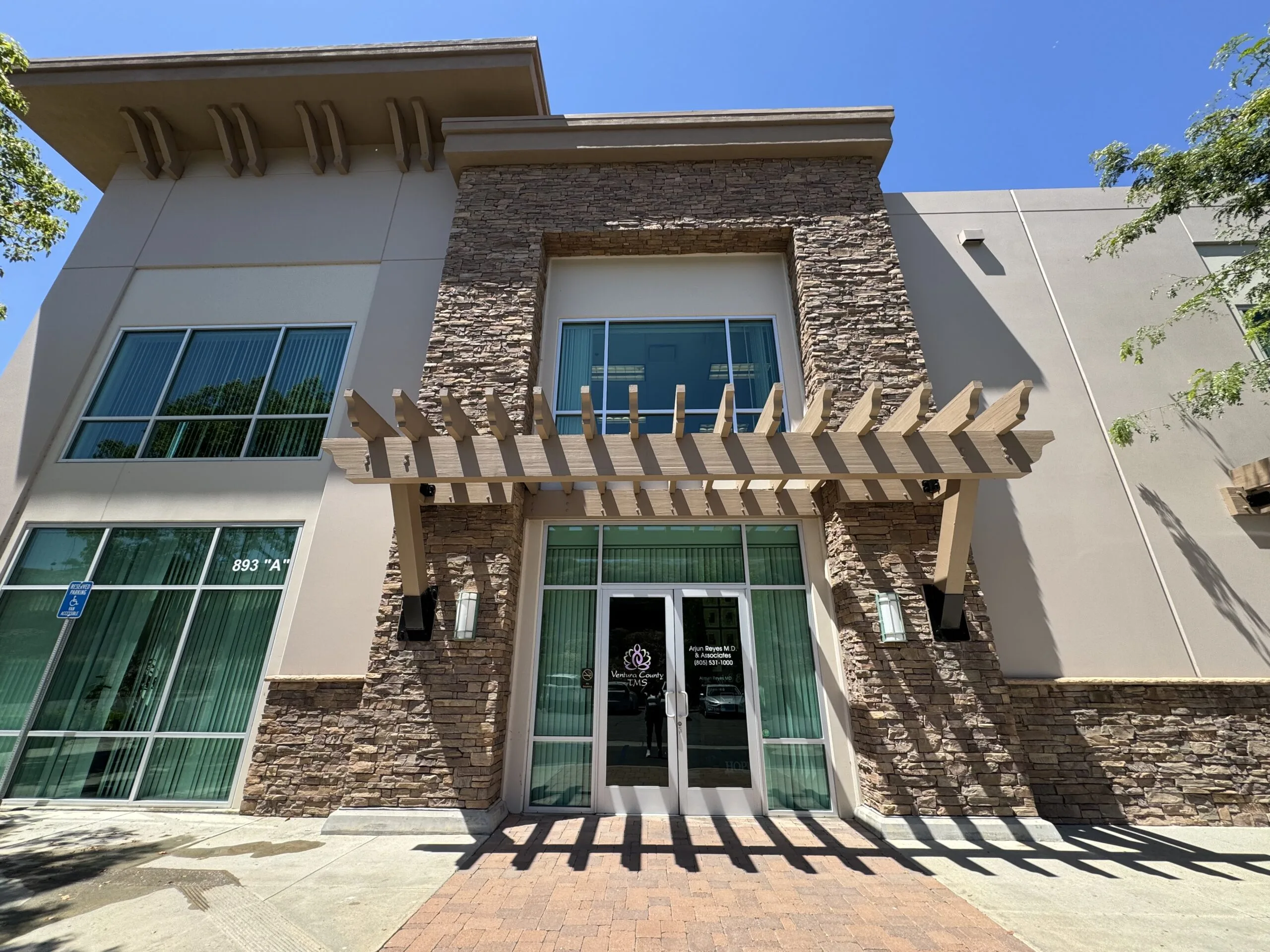 Modern medical office building exterior with stone accents and pergola