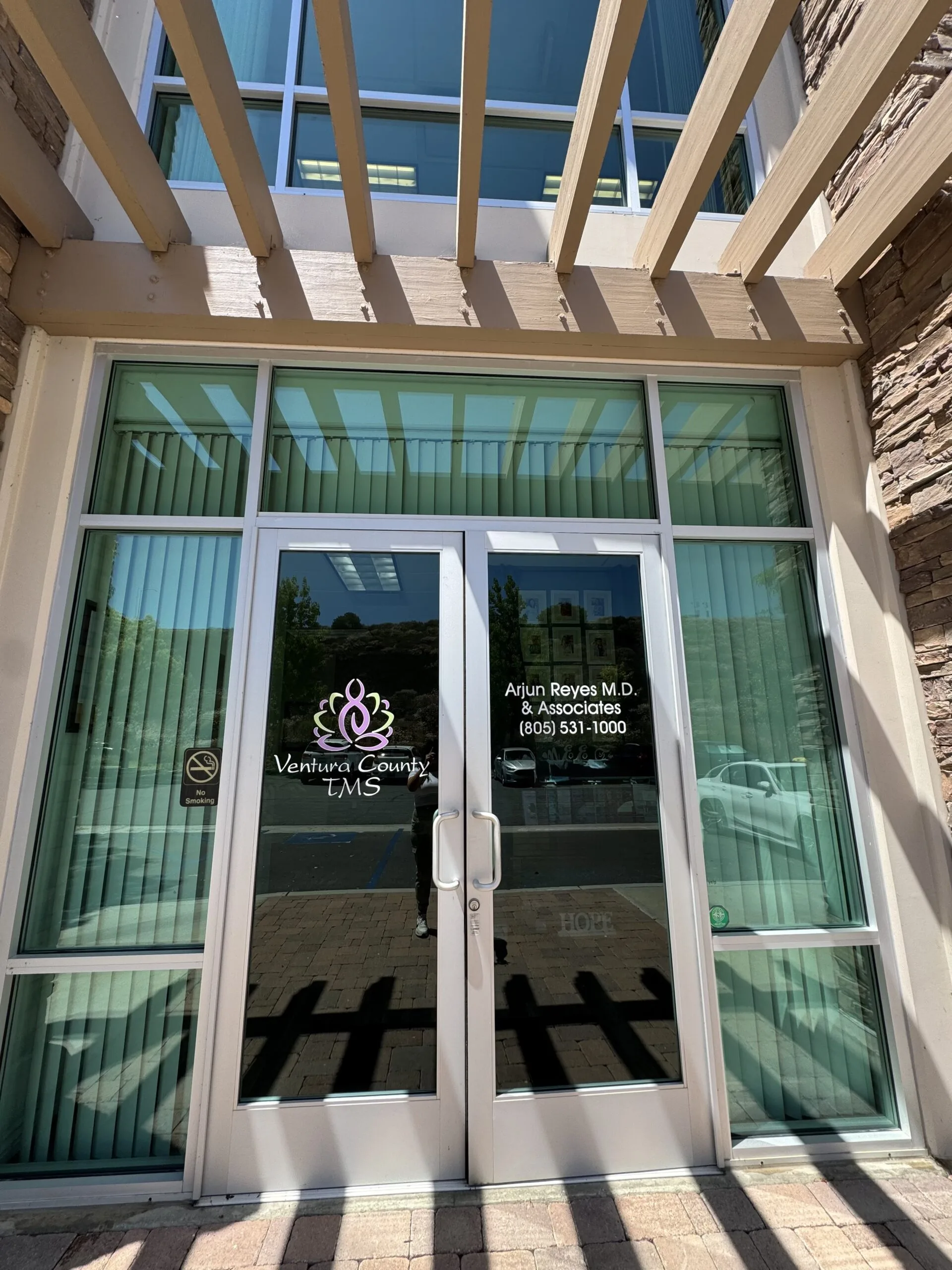 Glass entrance doors with Ventura County TMS and Arlun Reyes M.D. & Associates signage