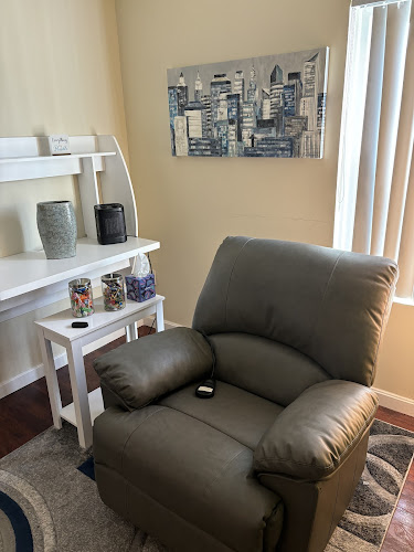 Infinity Treatment Center patient room with recliner chair and cityscape wall art