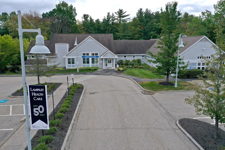 Lamprey Health Care facility exterior with white buildings, bell tower, and 50-year anniversary banner