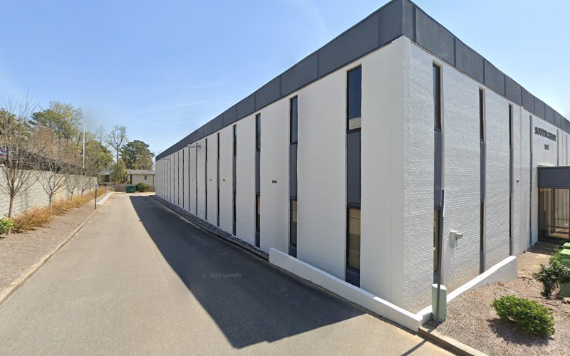 LifeWorks TMS modern white brick building with vertical window panels and paved pathway