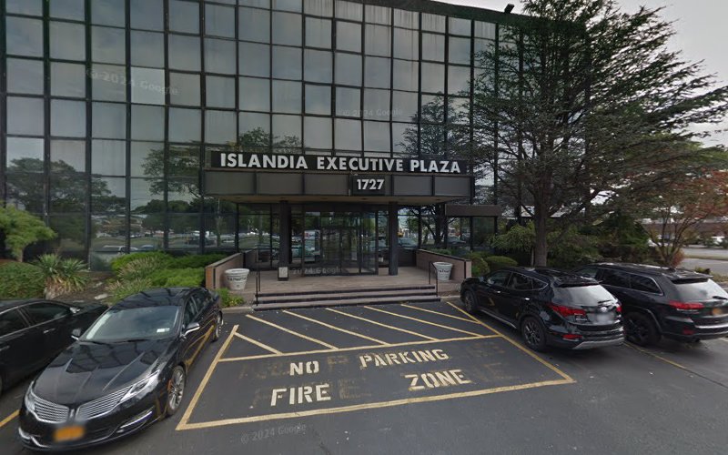 Islandia Executive Plaza building entrance at 1727 with glass facade, fire zone parking, and parked vehicles