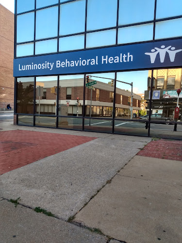 Luminosity Behavioral Health storefront with blue signage and glass entrance doors