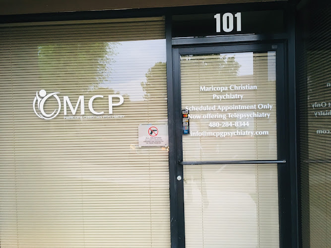 Maricopa Christian Psychiatry office entrance at unit 101 with OMCP logo and contact information on door