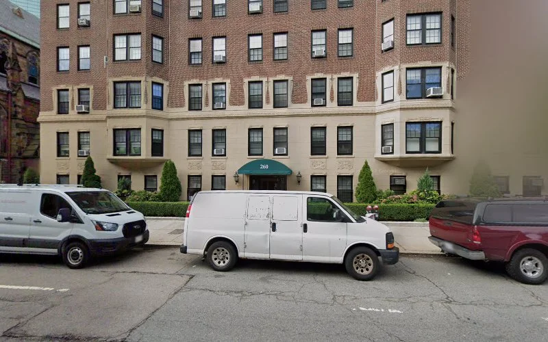 Massachusetts Mind Center LLC building entrance with teal awning at street level, parked vehicles in front