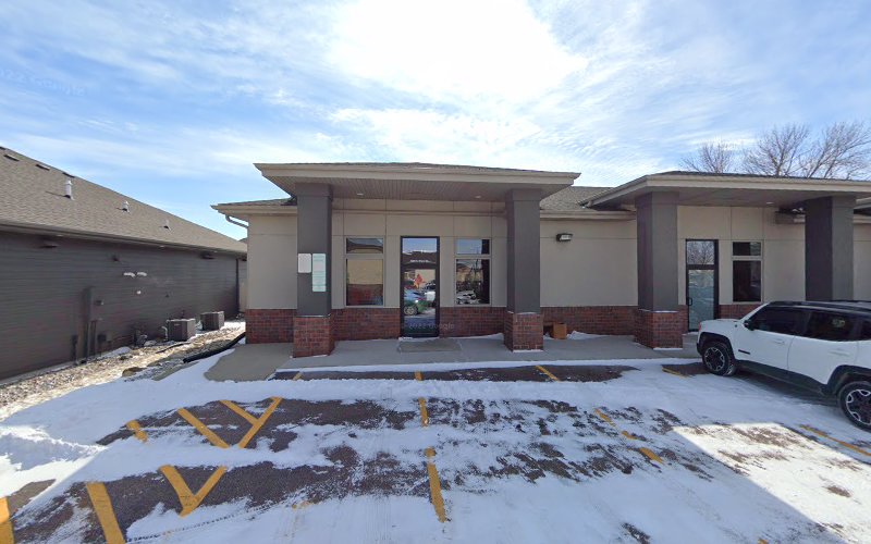Midwest Wellness Institute PLLC front exterior with brick and tan facade, entrance doors, and parking lot in winter