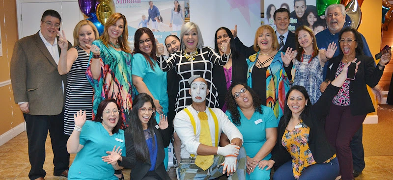 Team of mental health professionals in teal and colorful attire posing together indoors