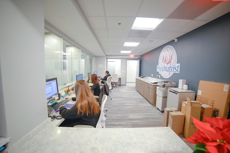 My Psychiatrist Falls Church office interior with staff at desks and blue wall with logo