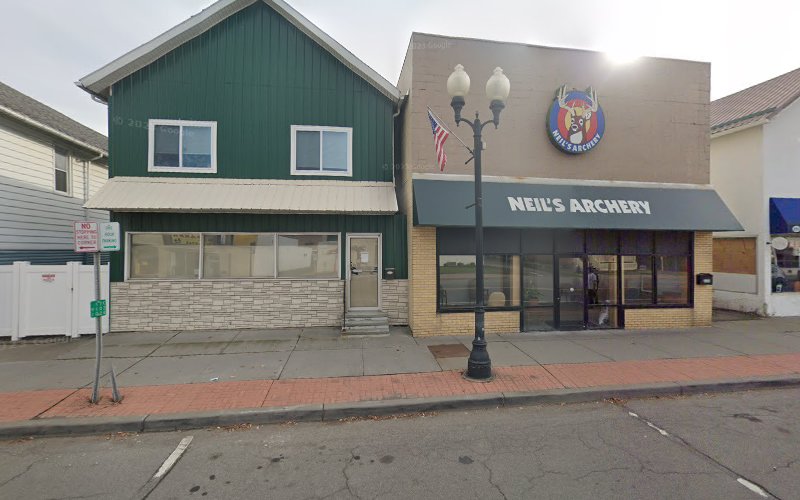 Street view of Neurosciences Group TMS therapy clinic in Endicott, NY, showing green and tan storefronts with street lamp