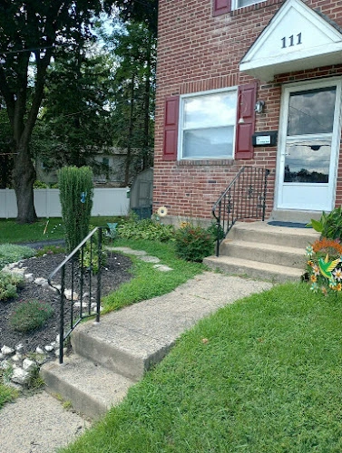 Brick building entrance with number 111, accessible ramp, and manicured landscaping