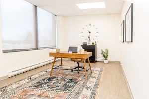 Northbrook clinic office with wooden desk, window, wall clock, and potted plant