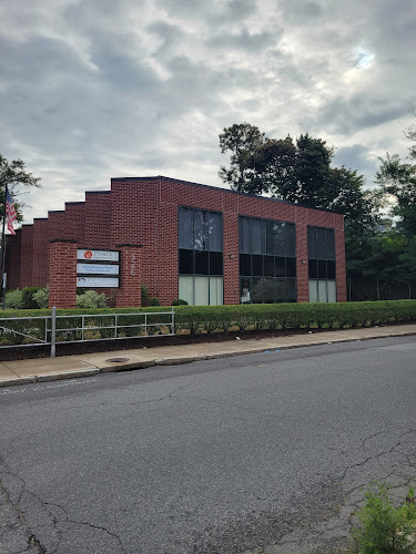 Red brick mental health facility building with large windows and metal railing