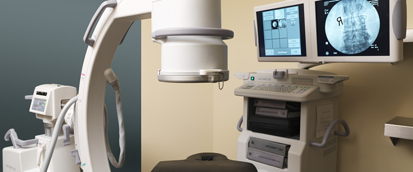 Pain management procedure room with C-arm imaging equipment and monitoring displays