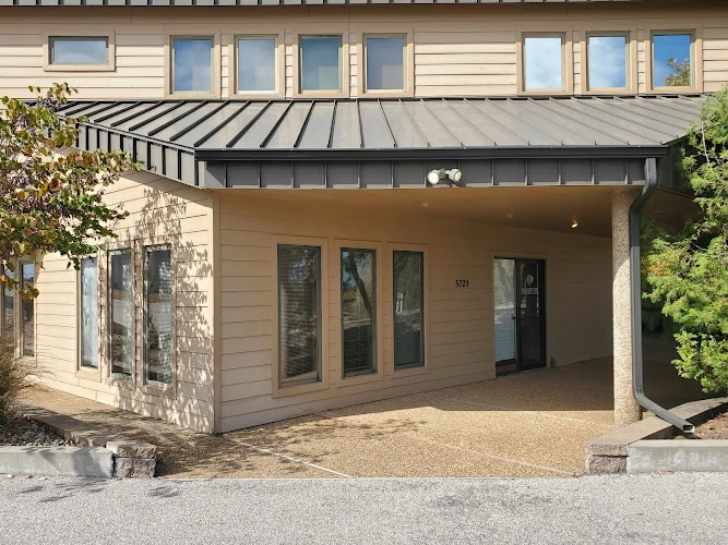 Modern medical clinic exterior with tan siding, metal awning, and glass doors in Osage Beach