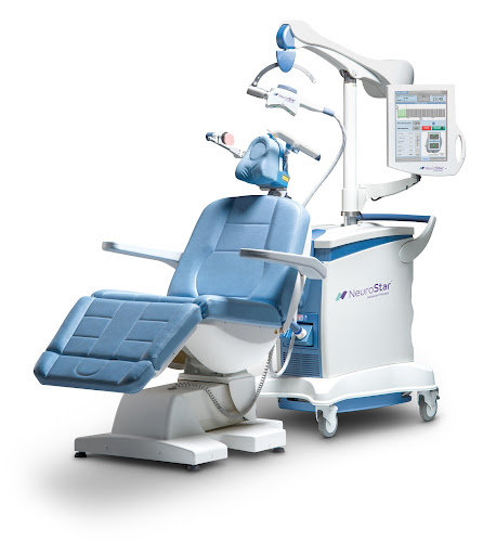Pelorus NeuroStar TMS machine with blue patient chair, coil applicator, and control panel