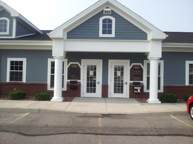 Penfield Psychiatry building exterior with blue siding, white columns, brick foundation, and double entrance doors