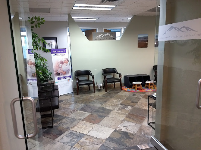 Philip Malinas M.D. & Associates waiting room with tiled floor, black chairs, decorative plant, and promotional banner