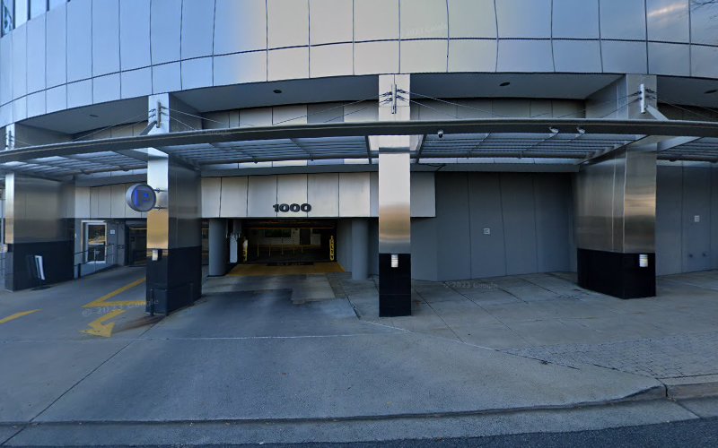 Modern building entrance with glass façade and address 1000 displayed on the entrance