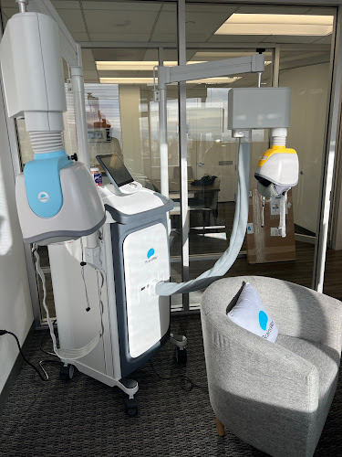TMS treatment room with multiple machines and comfortable seating area at Psychiatry Treatment Centers