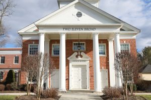 Red brick building with white columns and pediment labeled Two Eleven Broad, Office Suites