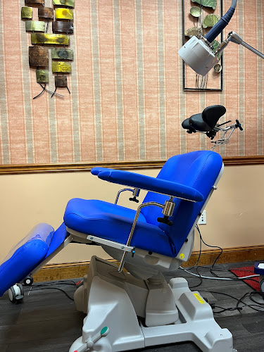 Blue TMS treatment chair with coil positioning apparatus in clinical office setting