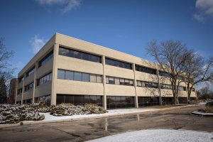 Multi-story concrete medical office building exterior with large windows and snow on ground