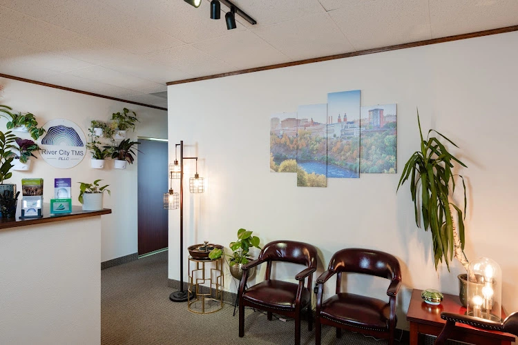 River City TMS PLLC reception area with brown leather chairs, potted plants, and cityscape artwork on walls