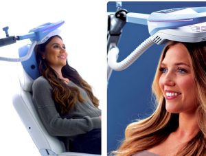 Two women receiving TMS therapy with magnetic coil headpieces against blue background