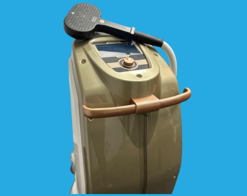 TMS therapy device with grey and tan casing and handheld magnetic coil applicator